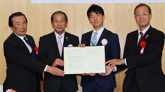 連携協定書に調印した八頭町長（左から2人目）とSBドライブ社長（左から3人目） （5月23日、JR郡家駅コミュニティー施設「ぷらっとぴあ・やず」＝鳥取県八頭町）